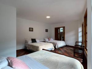 1 dormitorio con 2 camas y un pasillo con ventanas en Villa Pastaza 4 Bedroom 3 Bath, en Baños