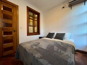 un dormitorio con una cama y una ventana en Villa Pastaza 4 Bedroom 3 Bath, en Baños