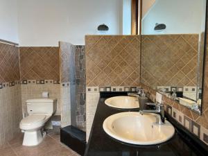 Un baño con dos lavabos y un inodoro. en Villa Pastaza 4 Bedroom 3 Bath, en Baños 23 fotos más