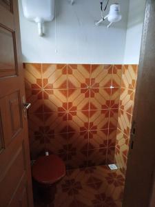 une salle de bain avec toilettes et un mur carrelé dans l'établissement Apartamento em Ibitipoca, à Conceição da Ibitipoca