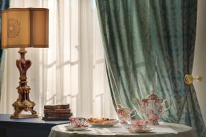 a table with a lamp and a tea set on it at Florence Dream Domus in Florence