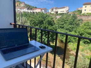 a laptop sitting on a table on a balcony at Casa do Cabecinho in Pampilhosa da Serra