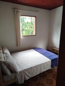 une chambre avec un lit et une fenêtre dans l'établissement Apartamento em Ibitipoca, à Conceição da Ibitipoca 2 autres photos