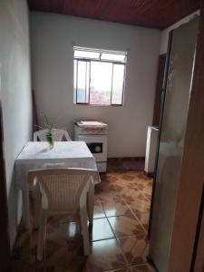 une petite cuisine avec une table et une fenêtre dans l'établissement Apartamento em Ibitipoca, à Conceição da Ibitipoca