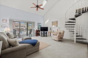 a living room with a couch and a stair case at 34j GCR-Ortiz Oasis in Myrtle Beach