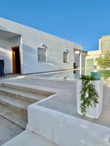 a building with stairs and plants in front of it at Résidence Azur Djerba in Taguermess