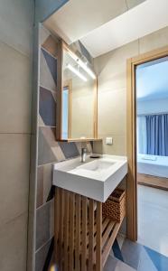 a bathroom with a white sink and a mirror at AGALI ROOMs in Perdika