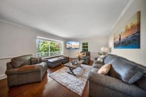a living room with a leather couch and a table at Magic on the Hill by Carolina Mornings in Asheville