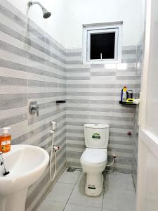 a bathroom with a white toilet and a sink at Harmony Apartments in Mombasa +18 photos