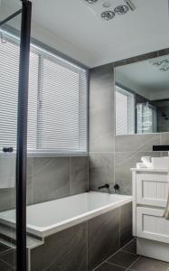 a bathroom with a bath tub and a window at Koblenz Haus - Tanundas Newest! in Tanunda +18 photos