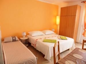 une chambre avec deux lits dans une pièce aux murs orange dans l'établissement Apartments by the sea Podgora, Makarska - 23678, à Podgora