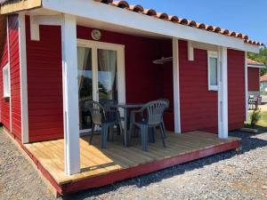 a deck with a table and chairs on a red house at Charming Apartment in Ardennes in Signy-lʼAbbaye