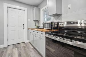 una cocina con estufa y microondas en Quaint 1BR 1BA near the falls, en Niagara Falls