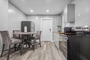 Una cocina con mesa y sillas y un refrigerador. en Quaint 1BR 1BA near the falls, en Niagara Falls