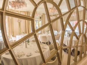 a reflection of a dining room with tables in a mirror at Le Stelsia Resort in Saint-Sylvestre-sur-Lot