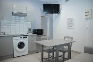 a kitchen with a table and a washing machine at Appartement en plein centre de Nîmes in Nîmes +5 photos