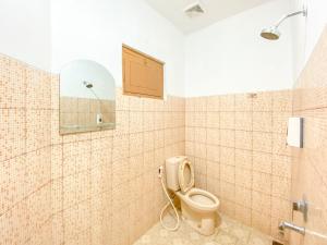 a bathroom with a toilet and a mirror at Hotel Maerakaca Tugu Yogyakarta Mitra RedDoorz in Jetis +53 photos