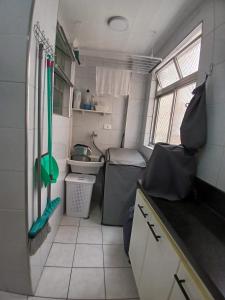 eine kleine Küche in einem Wohnwagen mit Spüle in der Unterkunft AP 1 Dorm Ponta da Praia Santos SP in Água Boa + 15 Fotos