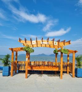 einen hölzernen Bogen mit einem Tisch am Strand in der Unterkunft AP 1 Dorm Ponta da Praia Santos SP in Água Boa