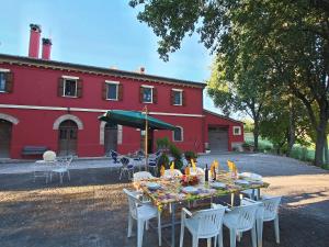 a table in front of a red building at Belvilla by OYO Casa Lella in Serrungarina