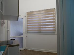 a kitchen with a window with a wooden blind at Terazije apartment in Belgrade