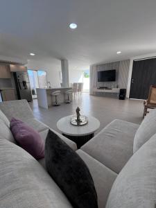 un salon avec un canapé et une table dans l'établissement Villa de Lujo con Piscina Privada y BBQ, Cerca al Mar - Casa Abigail, à Juan de Acosta