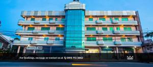 a tall building with green windows on a city street at Kingsway Iligan Hotel in Iligan