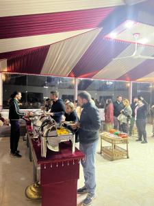 a group of people standing around a table with food at Kylie magic camp in Wadi Rum