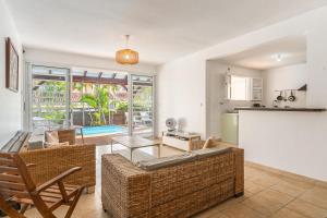 una sala de estar con un sofá y una mesa en Villa Babaïa, A peaceful oasis, en Le Diamant