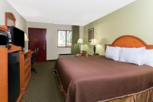 a hotel room with a bed and a flat screen tv at Howard Johnson by Wyndham Tallahassee in Tallahassee