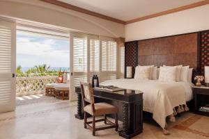 a bedroom with a bed and a desk and a balcony at One&Only Palmilla in San José del Cabo +37 photos