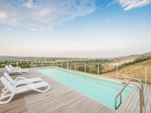 a swimming pool with two lounge chairs on a deck at Villa Renzo in Notaresco