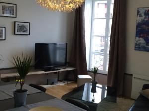 a living room with a television and a window at Wine Home in Chambéry