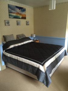 a bedroom with a large bed with a black comforter at The Glen Farmhouse in Glenfleak