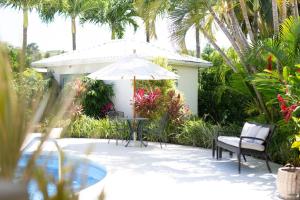 eine Terrasse mit Tisch, Stühlen und Sonnenschirm in der Unterkunft Gibbs Glade Villa By Bluescape in Saint Peter
