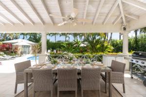 einen Esstisch mit Stühlen und einen Deckenventilator in der Unterkunft Gibbs Glade Villa By Bluescape in Saint Peter
