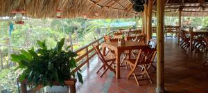 a restaurant with wooden tables and chairs and a patio at Tayrona de Lujo in Santa Marta