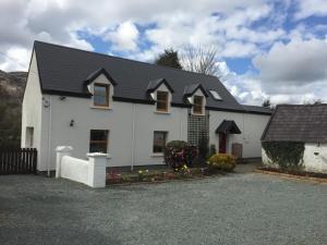 a white house with a black roof at The Glen Farmhouse in Glenfleak