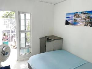 a white bedroom with a bed and a window at Rest 3 in Santa Marta