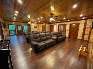 a large living room with a leather couch and wooden floors at On Mountain Time in Sevierville