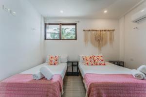 a room with two beds with towels on them at Depto de Playa con vista Alberca in Chicxulub +26 photos