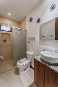 a bathroom with a toilet and a sink and a shower at Depto de Playa con vista Alberca in Chicxulub