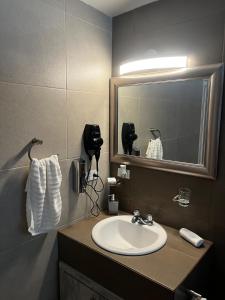 a bathroom with a sink and a mirror at AXEL Suites Departamento 1A in Delicias +5 photos
