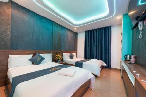 una camera d'albergo con due letti e una televisione di Khách Sạn Tân Hoàng Yến ad Ho Chi Minh