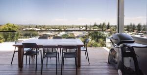 a wooden deck with a table and chairs on a balcony at Bay Properties The Chill in Yamba +15 photos