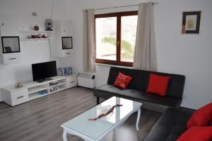 een woonkamer met een zwarte bank en een tafel bij Apartments Nina in Baška