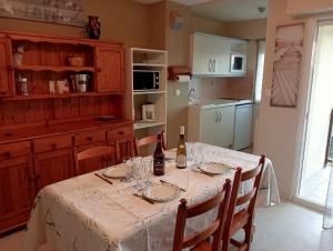 a kitchen with a table with two bottles of wine at Résidence des argonautes in Arzon