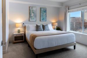 a bedroom with a large bed and a window at Convention Ctr Lux 2BR Pool,Htub,Gym,Theatre,Pkg in Salt Lake City