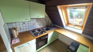 een kleine keuken met een fornuis en een raam bij Chalet Schluchsee Ferienwohnung in Schluchsee +18 foto's