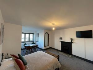 a bedroom with a bed and a fireplace and a table at Upper Harbour Watch in Holyhead
